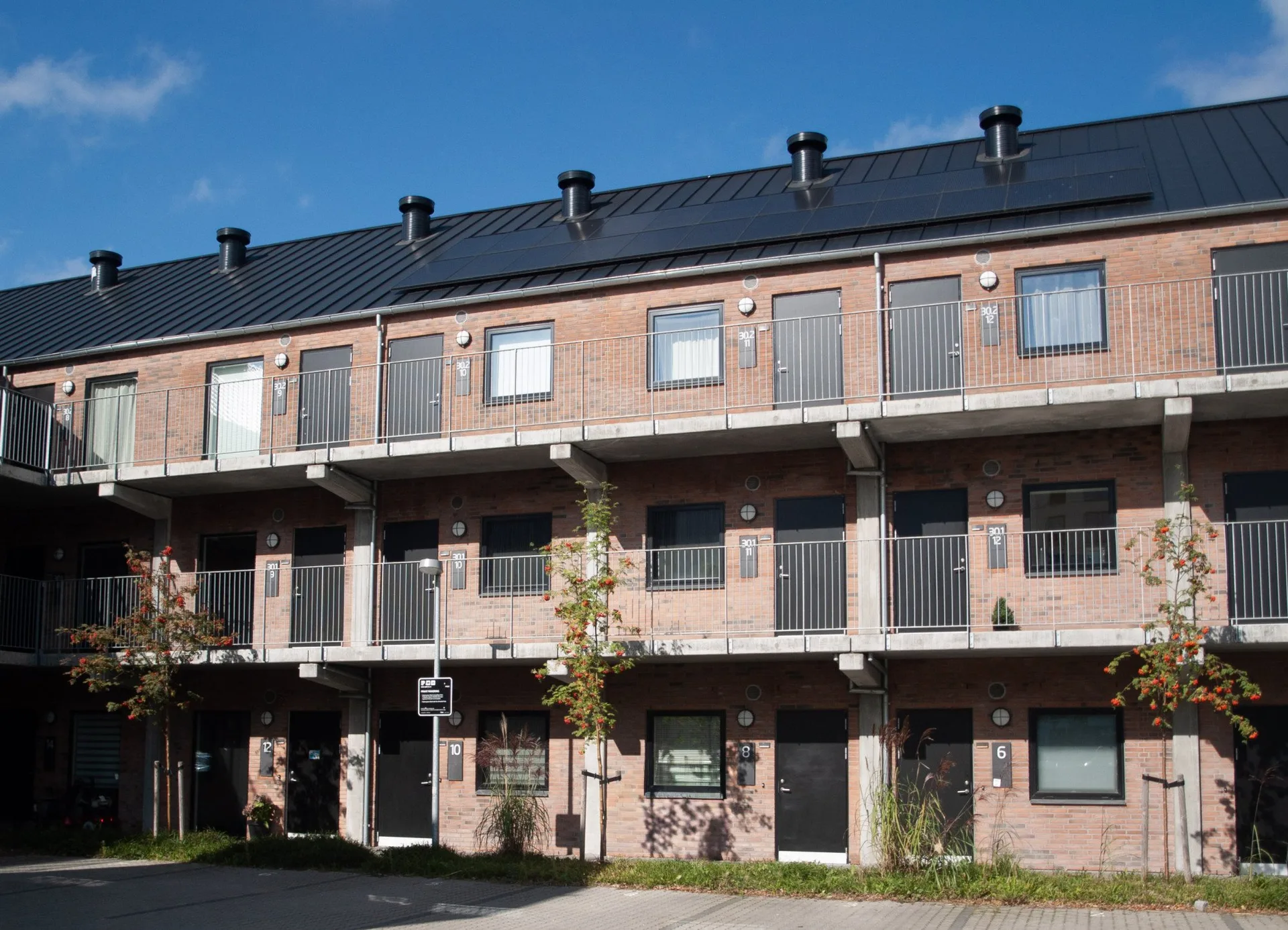 Tunøgade i Horsens: boliger i rød tegl over tre etager med altangange mod gården