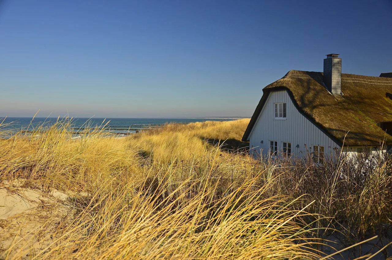 Et stråtækt sommerhus i klitterne ved havet