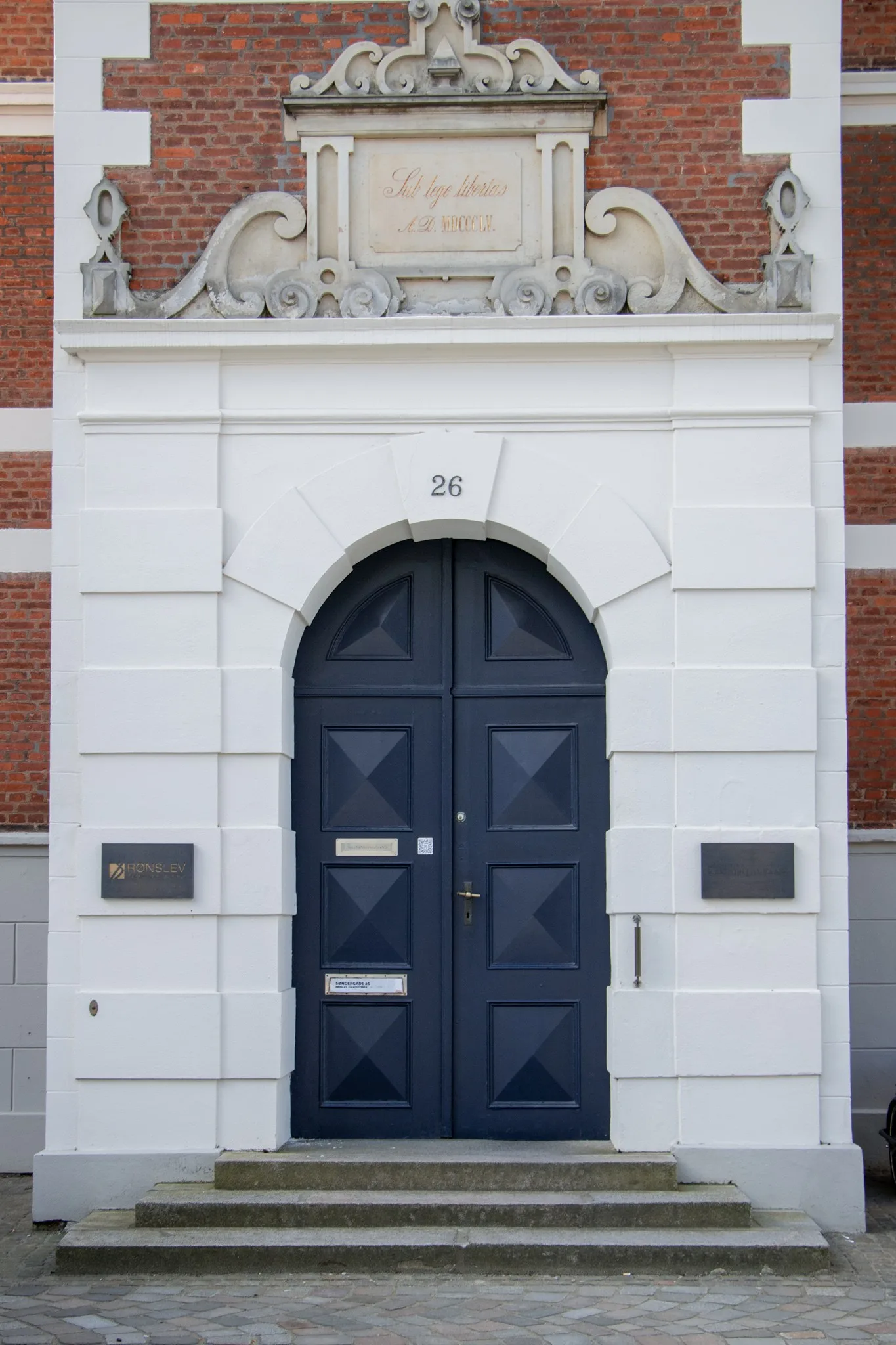 Indgangen til Det Gamle Rådhus i Horsens: blå dobbeltdør i en hvid portal, nummer 26