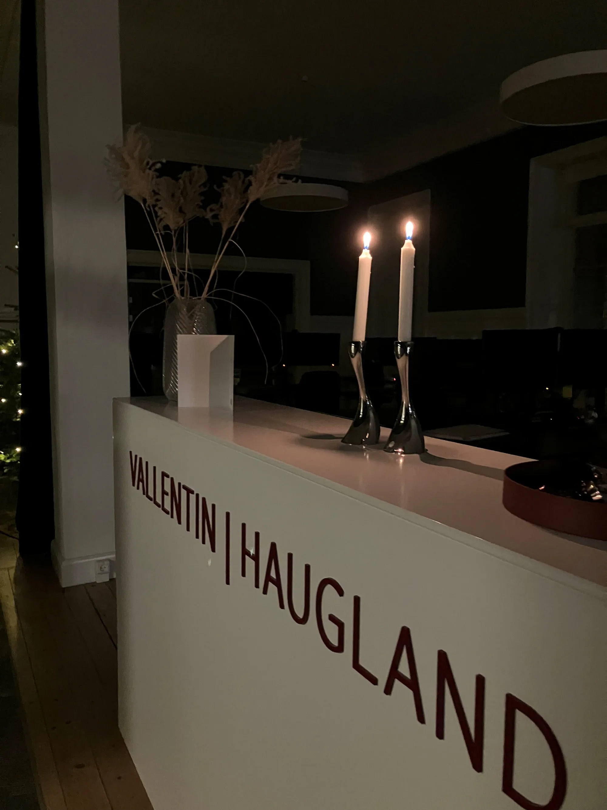 Receptionen på tegnestuen med logoet på disken og tændte stearinlys