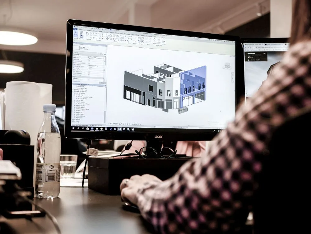 En 3D-model af en bygning på en skærm på tegnestuen